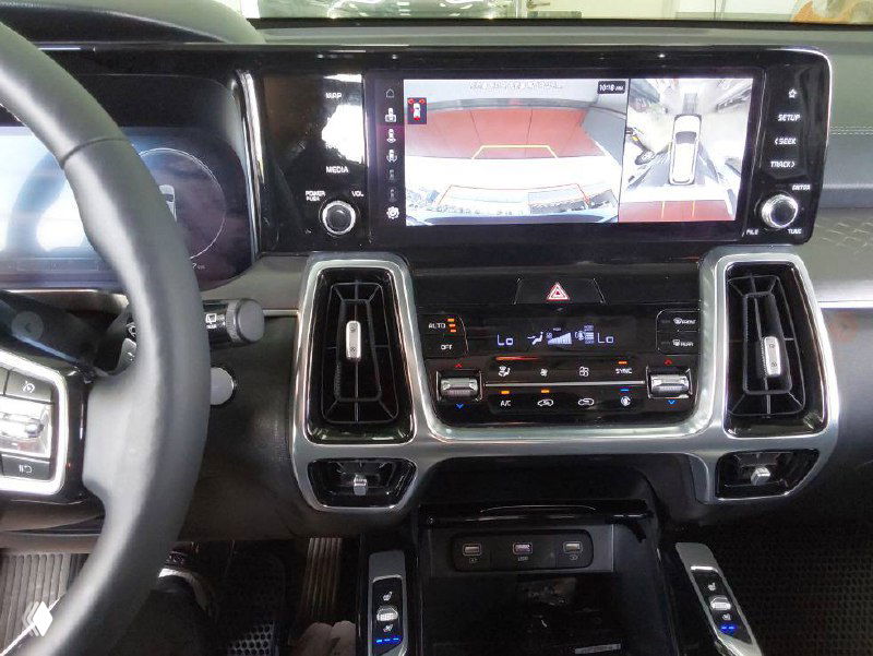Центральный экран мультимедиа и камера заднего вида Kia Sorento 2021, отображение режима парковки на мониторе и элементы управления климата.