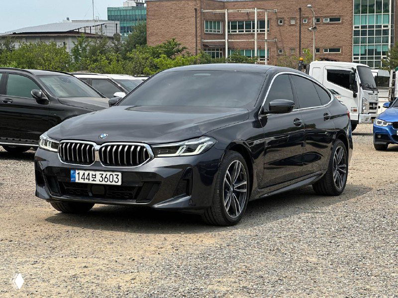 Чёрный BMW GT 620D XDrive M Sport в трёхчетвертном ракурсе справа, видны колёса, боковой профиль и отражения на кузове автомобиля.