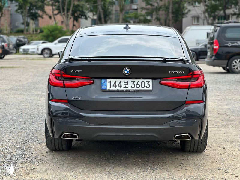 Крупный вид сзади BMW GT 620D, заметен номер и эмблема модели, автомобиль на стоянке с чётким изображением кормы и выхлопных патрубков.