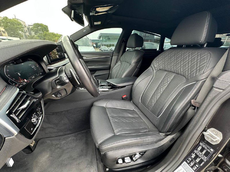 Передние сиденья BMW GT 620D в чёрной кожаной отделке с декоративной прострочкой, видны органы управления сиденьем и хорошее состояние салона.