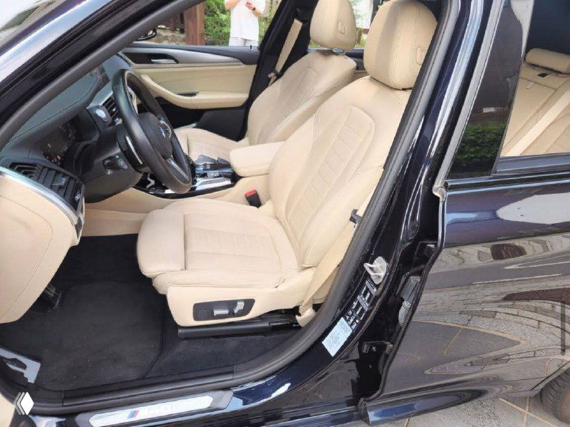 Передние сиденья BMW X3 M40i с бежевой кожаной отделкой: видны регуляторы сидений и чистая внутренняя обивка салона.