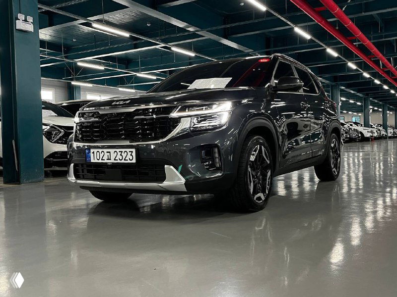 Наклонный ракурс передней части Kia Seltos Signature 2024: крупный план решётки радиатора, светодиодных фар и декоративных элементов бампера.