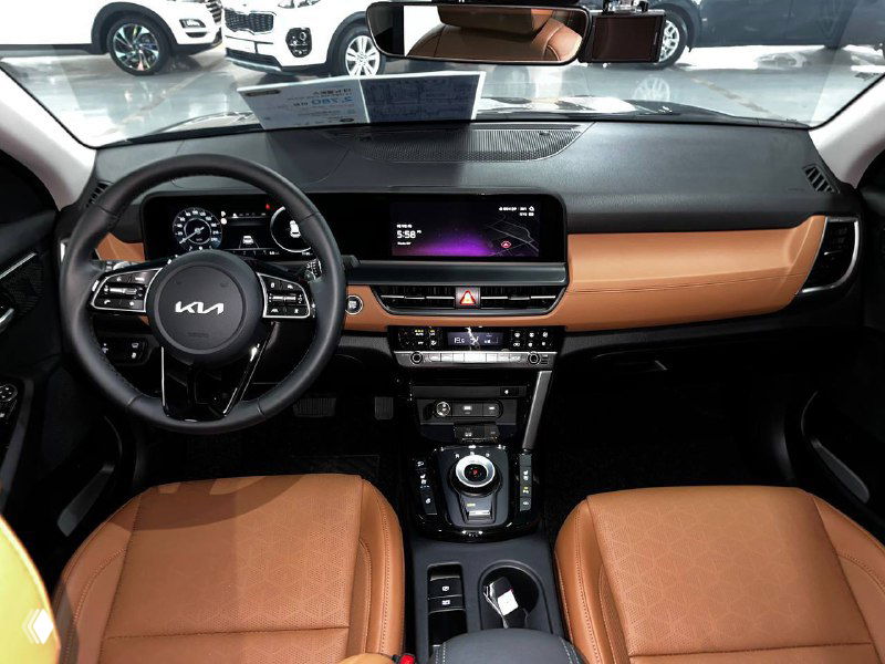 Салон Kia Seltos Signature 2024: панель приборов, широкий сенсорный экран мультимедиа, коричневая отделка торпедо и многофункциональный руль.