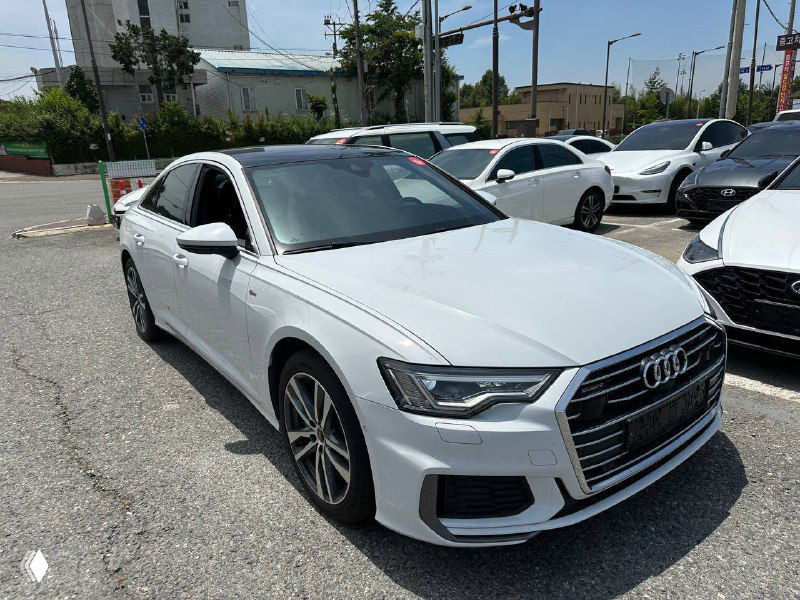 Белая Audi A6 2021, вид в профиль с переднего левого ракурса, ровные линии кузова и заводская окраска на солнце.