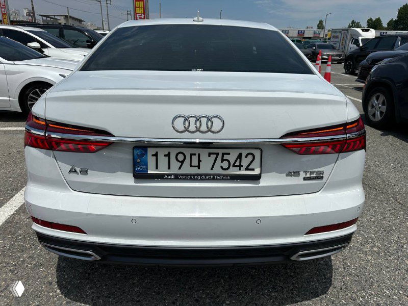 Задняя часть Audi A6 с корейским номером, светодиодные фонари и логотип Audi, вид на парковке дилера.