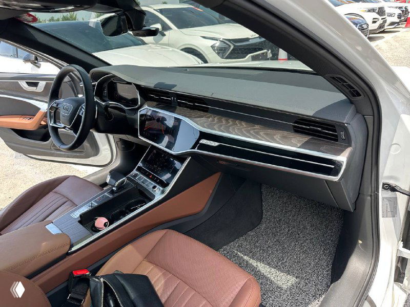 Салон Audi A6: передняя панель, центральная консоль и мультимедиа, коричневая кожаная отделка и декоративные вставки.