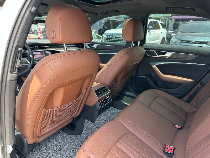 Задние сиденья Audi A6 с коричневой кожей, вид на пространство для ног и состояние обивки салона.