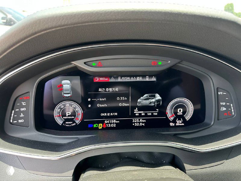 Цифровая приборная панель Audi A6 с включённым экраном, отображение режимов движения и пробега, крупный план щитка приборов.