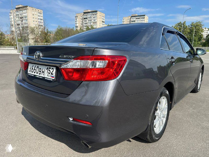Ещё один ракурс задней части серой Camry V50 с небольшим углом обзора; видно форму фонарей и задний бампер вблизи.