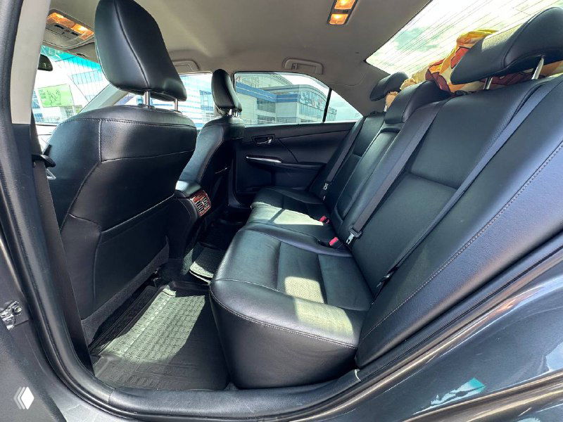 Задний ряд сидений в салоне Camry V50: чёрная кожа, свободное пространство для пассажиров и чистые напольные коврики на фото.