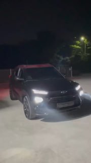Ночной кадр автомобиля Chevrolet Trailblazer на улице с включёнными фарами: общий силуэт машины, световые полосы и движение колес видны в сумерках.