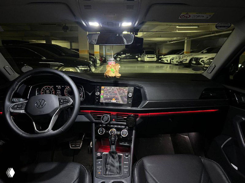 Широкий кадр торпеды и центральной консоли Volkswagen Jetta с навигацией, подсветкой и элементами управления в салоне.