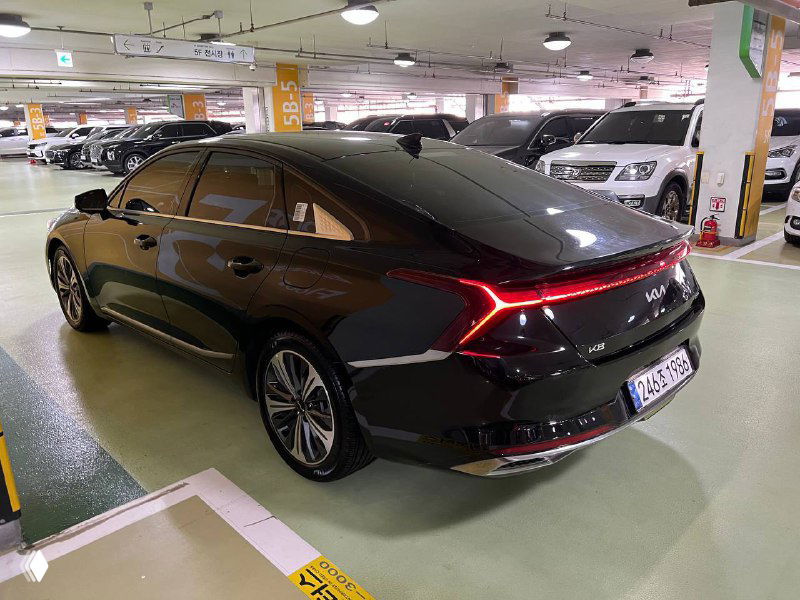 Крупный заднебоковой ракурс Kia K8 — контуры крыши, багажника и задних фонарей, автомобиль на стоянке Floor 5