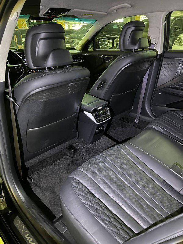 Задний ряд сидений Kia K8 — чёрная кожа, простор для ног, вид со стороны задней двери и центральный тоннель с воздуховодами