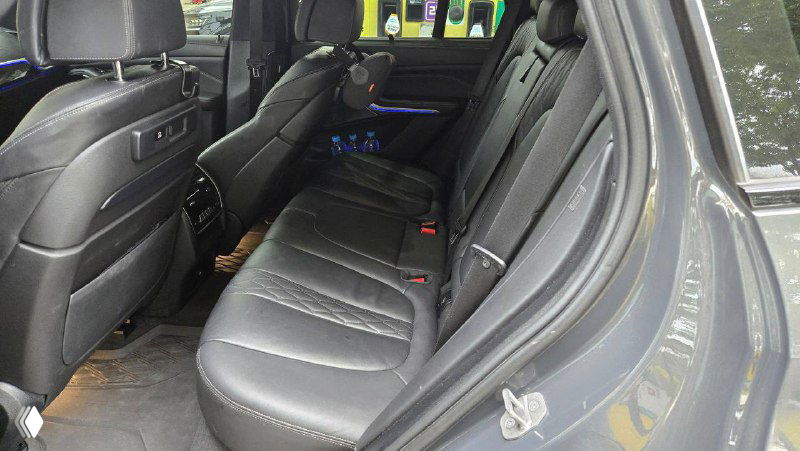 Дополнительный ракурс заднего ряда и дверного проёма BMW X5 40D, видно пороги и крепления, крупный план состояния салона около двери.