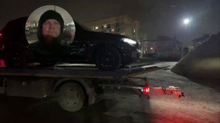 Чёрный BMW X5 демонстрируется на платформе грузовика ночью, видна общая силуетная форма автомобиля и световые приборы эвакуатора.