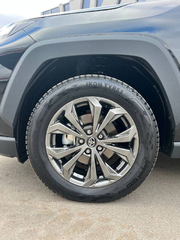 Крупный план легкосплавного колёсного диска R18 на Toyota RAV4, вид на протектор и место крепления диска.