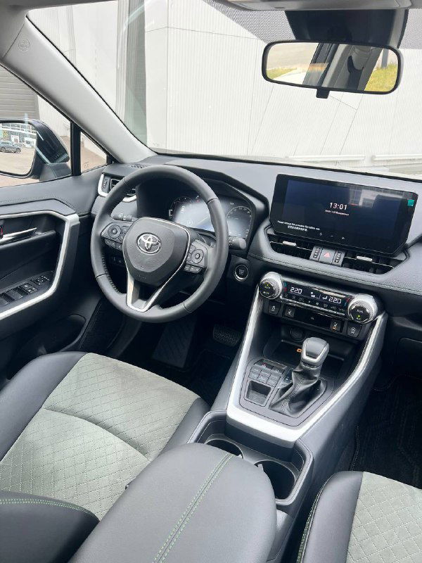 Передняя панель и рулевое колесо Toyota RAV4: мультируль, экран медиасистемы и элементы управления в салоне.