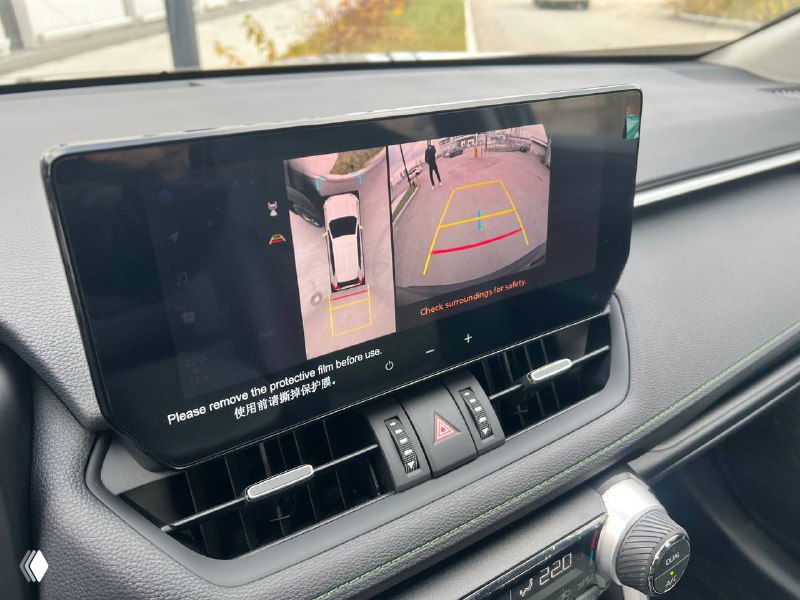 Экран медиасистемы Toyota RAV4 с включённым режимом камер 360 градусов и изображением парковочной разметки на дисплее.