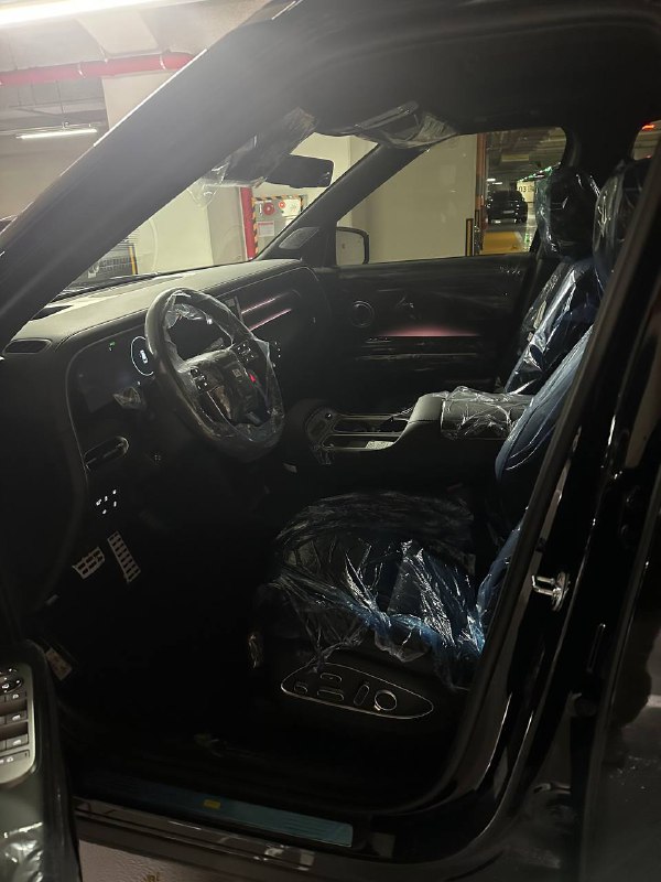 Салон водителя Hyundai Palisade 2025: сиденье и передняя панель закрыты защитной плёнкой, видны элементы управления и мультимедиа.