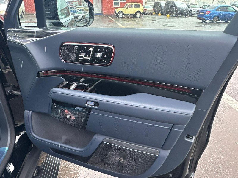 Деталь дверной панели Zeekr 9X с элементами управления, подсветкой и отделкой кожей/карбоном, вид крупным планом