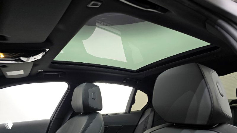 Панорамный крыша и передние сиденья BMW 5‑Series 530i xDrive M Sport 2025, обзор стеклянного люка и освещения в салоне, демонстрация опций автомобиля