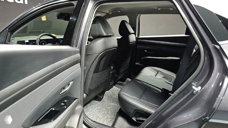 Задний ряд сидений Hyundai Tucson: места для пассажиров, откинутые спинки и обшивка салона, вид с открытой задней двери.