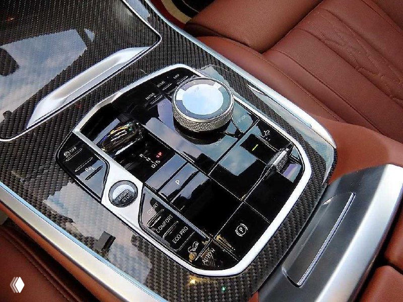 Центральная консоль BMW X7: селектор передач, поворотный контроллер iDrive и элементы отделки под карбон, вид сверху