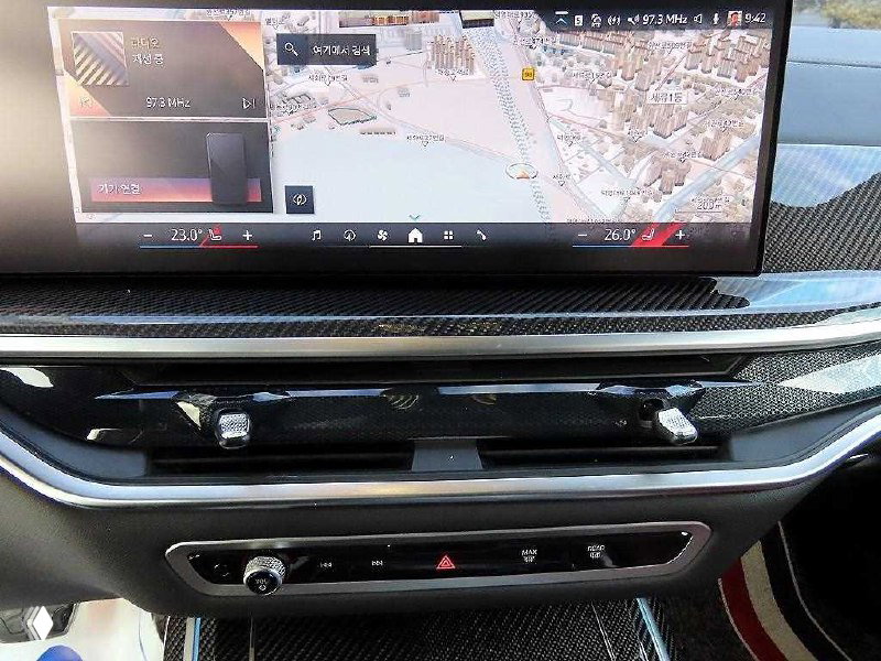 Панель мультимедиа и навигационная экранная часть BMW X7 с картой и элементами управления климатом и медиасистемы