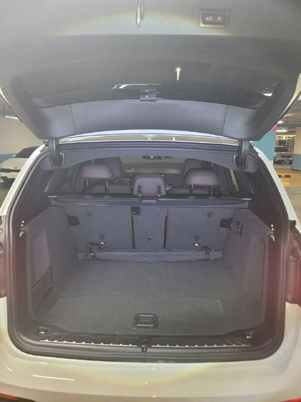 Открытый багажник BMW X3 xDrive 20i MSport 2024 года — вид внутрь грузового отсека, складывающиеся сиденья и отделение багажника.