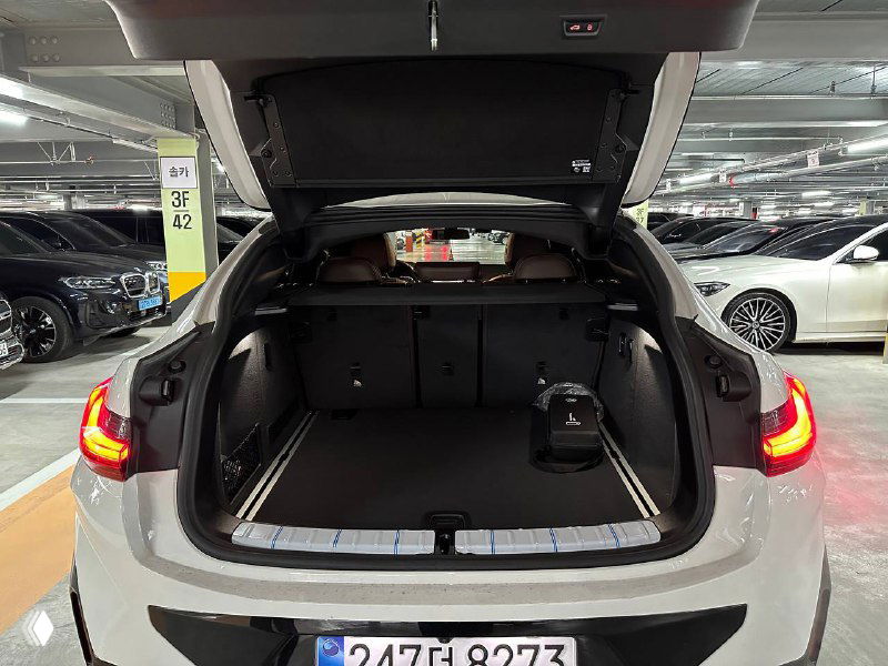 Открытый багажник BMW X4 — пространство багажного отделения, ровный пол и вид на задние сиденья со статусом готовности к загрузке.