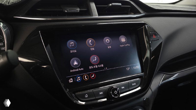 Мультимедийный сенсорный экран Chevrolet Trailblazer с отображением главного меню, кнопки управления и часть передней консоли крупным планом.