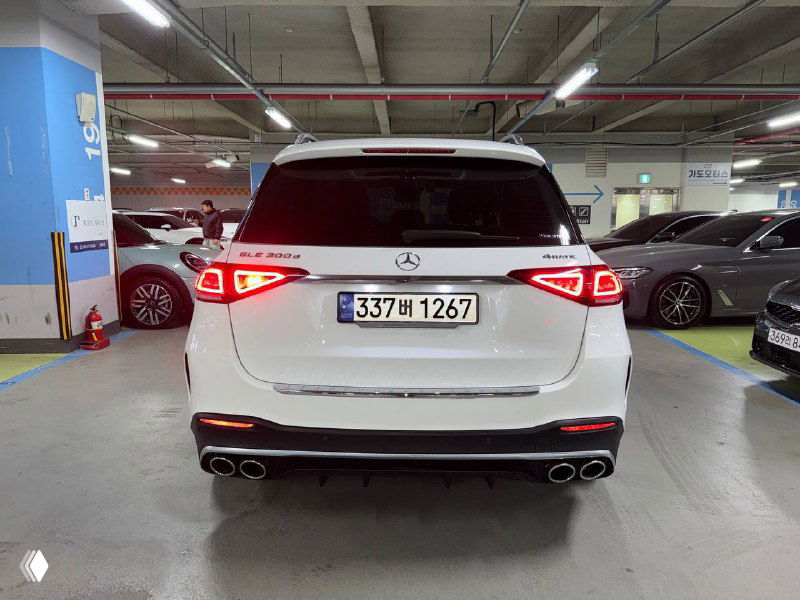 Прямой вид на корму белого Mercedes GLE 300D в паркинге: открытая багажная линия, задние фары и нижняя часть бампера видны отчётливо.