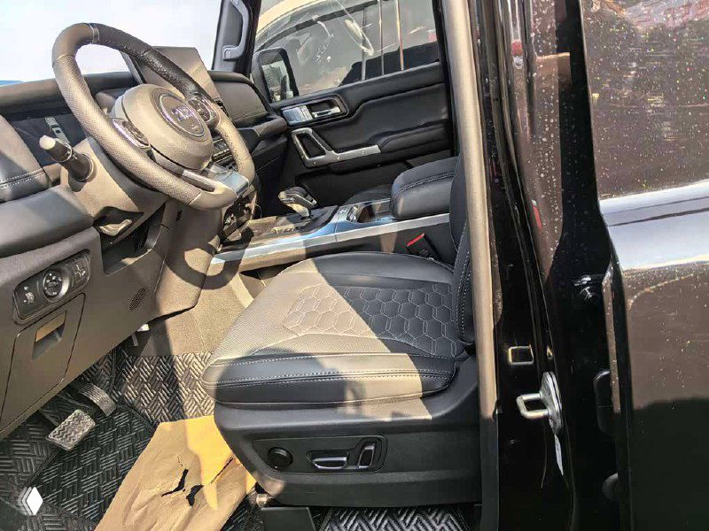 Интерьер BAW 212 T01: водительское сиденье, руль и часть панели, видны регулировки сиденья и материал обивки.