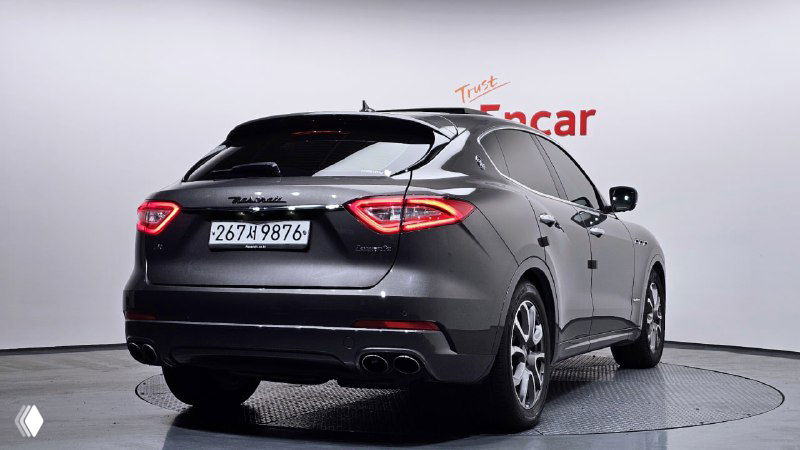 Maserati Levante вид сзади-слегка под углом, видны задние фонари, габариты и профиль кроссовера в выставочном боксе.