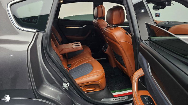 Задняя часть салона Maserati Levante: задние сиденья, подлокотник и аккуратные декоративные вставки на дверях.