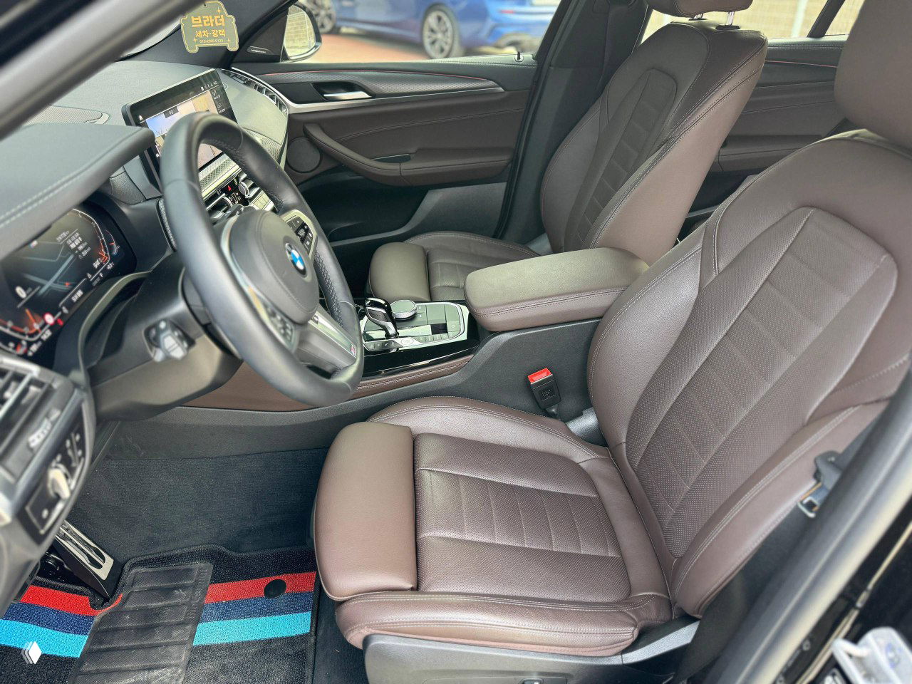 Цифровая приборная панель BMW X4 с показаниями пробега около 7 700 км, тахометр и спидометр в цифровом формате M‑серии.