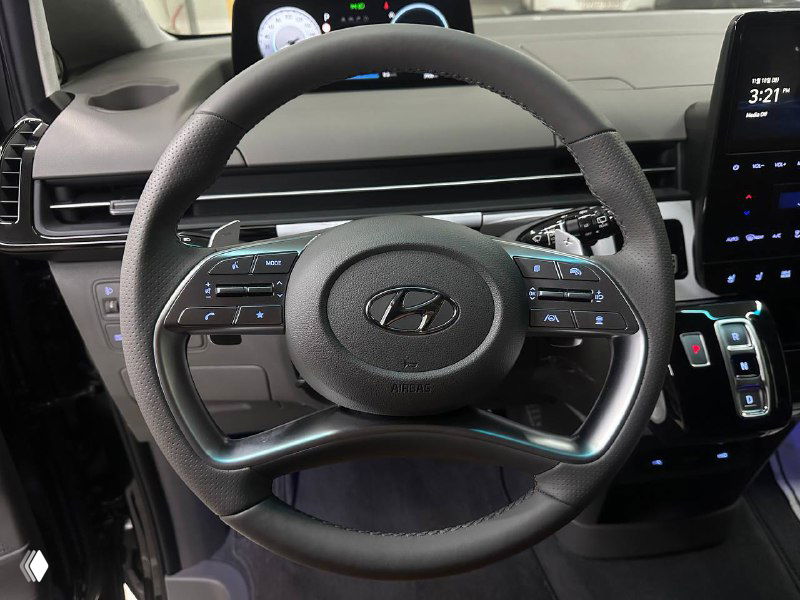 Руль Hyundai с мультимедийными кнопками и центральным логотипом Hyundai, крупный план панели управления и органов управления на руле.