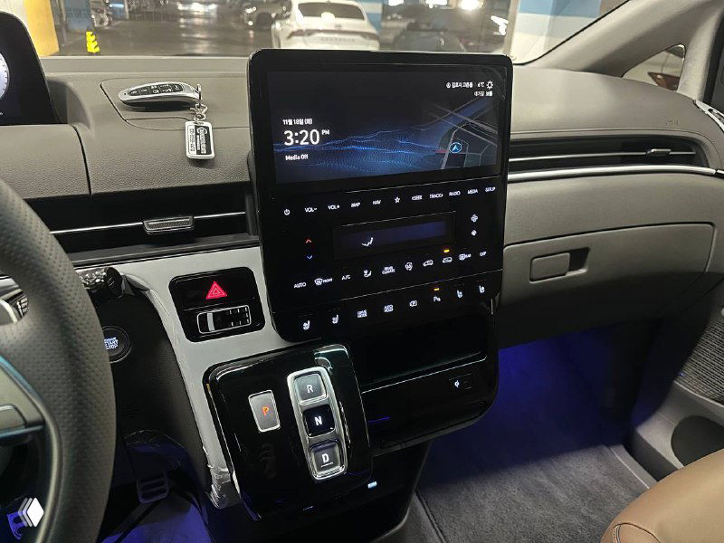 Центральная консоль Hyundai Staria с вертикальным сенсорным дисплеем, блоком климат‑управления и подсветкой в салоне крупным планом.