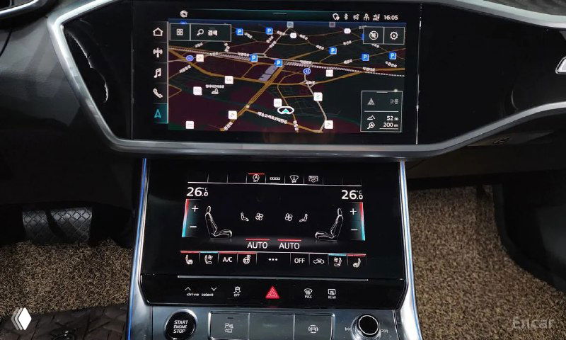 Центральный мультимедийный экран Audi A6 с картой навигации на дисплее, сенсорный климат-контроль и панель управления под экраном.