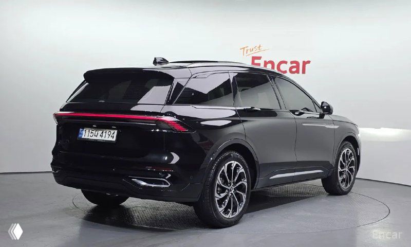 Lincoln Nautilus 2023 — задний ракурс в чёрном цвете, видно линию крыши, фон шоурума и световую полосу на корме автомобиля.