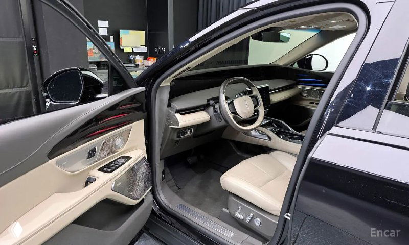 Открытая передняя дверь Lincoln Nautilus 2023, вид на водительское сиденье, панель двери с подлокотником и элементы отделки салона.