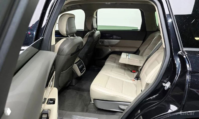 Вид на второй ряд сидений Lincoln Nautilus 2023 с угла, показывающий отделку, боковые панели и часть напольного покрытия салона автомобиля.