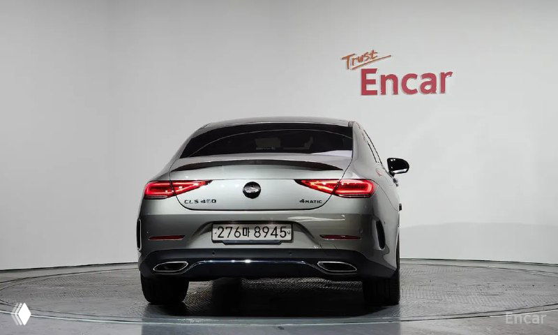 Вид сзади серебристого Mercedes‑Benz C257 CLS450 2022 года — видны задние фонари, номер и общая форма кузова в экспозиции дилера.