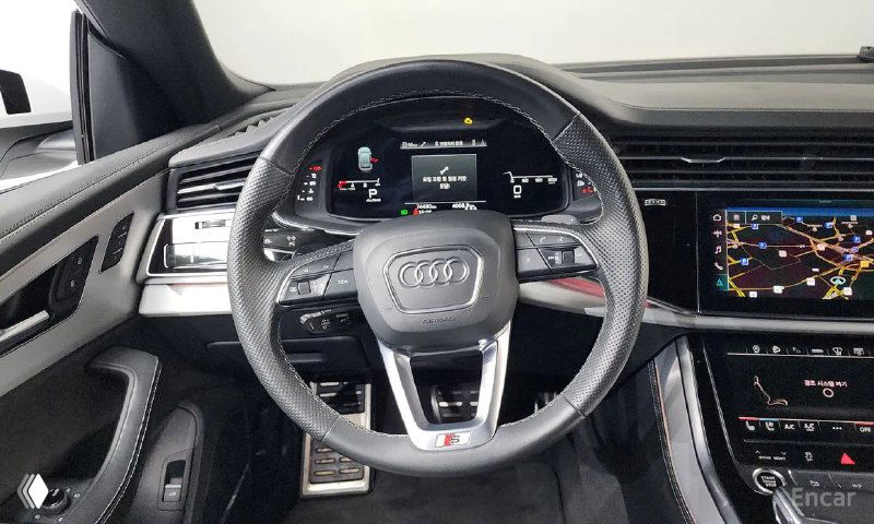 Руль и цифровая приборная панель Audi Q8: видно мультируль, виртуальную приборку и карту на центральном экране, изображение демонстрирует оснащение машины.
