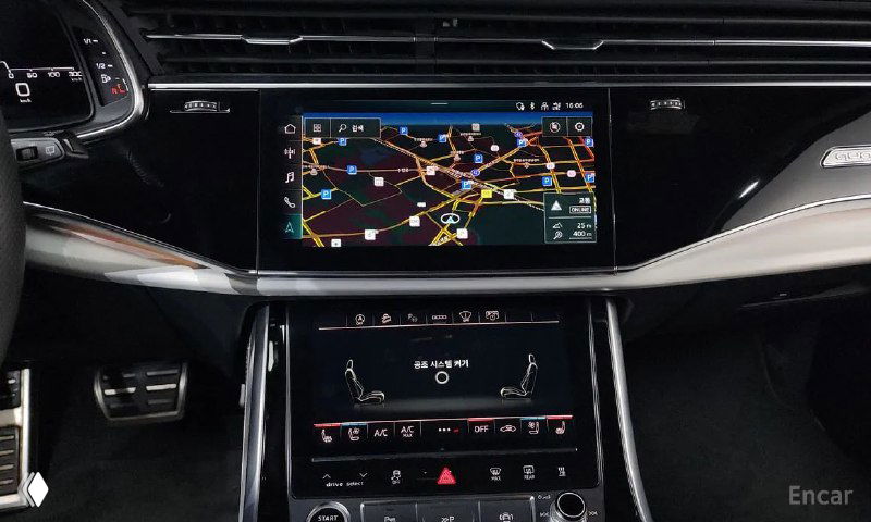 Крупный план центрального мультимедийного экрана Audi Q8 с картой навигации на дисплее и панелью климата под ним, интерфейс включён и читаем.