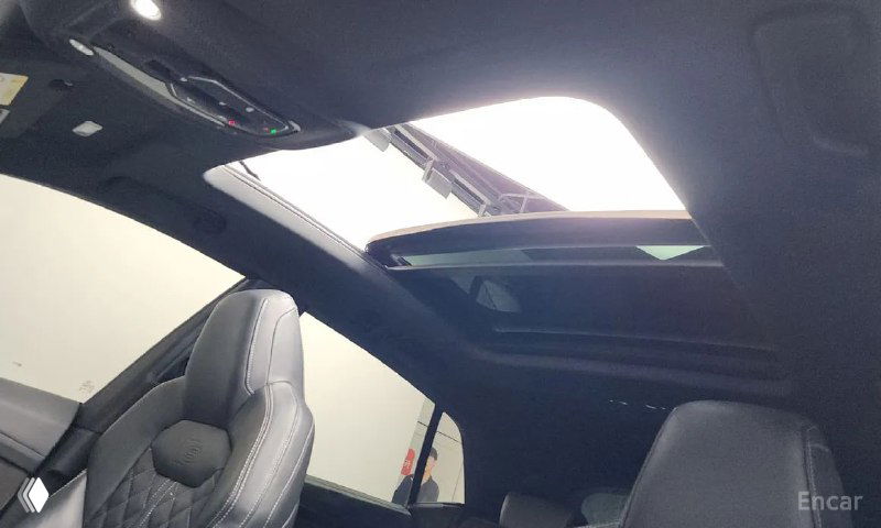 Панорамная крыша Audi Q8 — открытый люк в крыше, виден верхний световой проём и часть отделки потолка, подчёркивает комплектацию Premium.