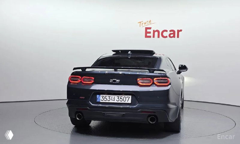 Chevrolet Camaro SS 2021 — вид сзади: двойные выхлопы, задние фонари и открытая площадка демонстрационного стенда Encar.