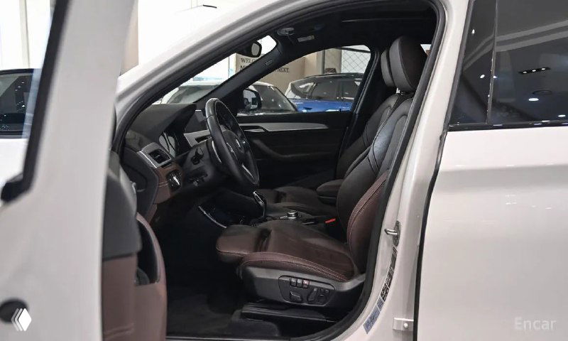 Переднее пассажирское сиденье BMW X1 в коричневой кожаной отделке — вид сбоку, регулировки и общее состояние кресла.