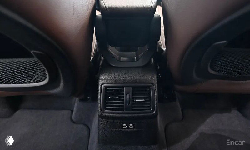 Задняя консоль BMW X1 между сиденьями: вентиляционные решётки и порты USB, демонстрирующие комфорт и оснащение салона для пассажиров.